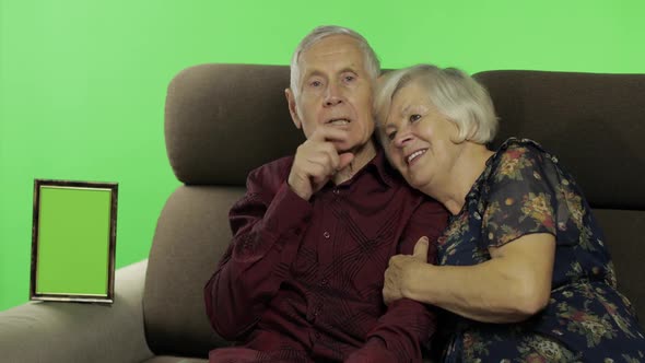 Senior Aged Man and Woman Sitting Together on a Sofa and Talking. Chroma Key