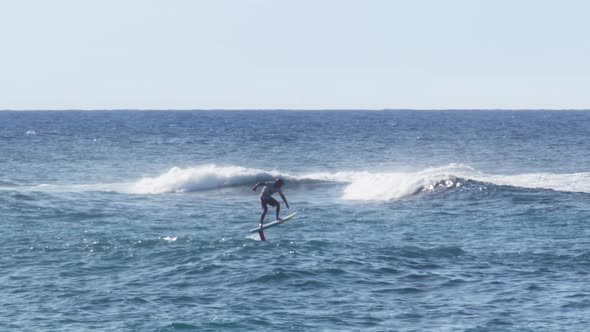 Athletic Nan Rides a Foilboard By Using the Power of the Ocean Wave Water Sport