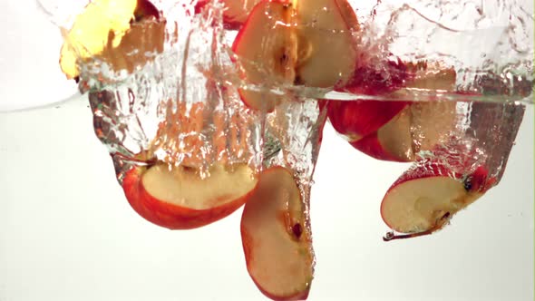 Super Slow Motion Pieces of Ripe Apple Fall Into the Water with Splashes