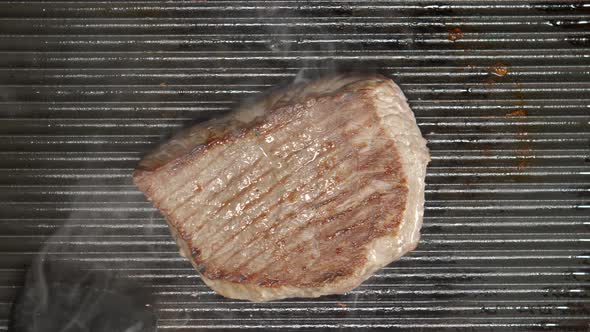 Cook Inverts A Beef Steak On A Grill