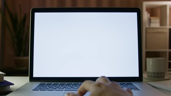 Close Up on Hands of Specialist Working on Laptop Computer with White Screen Mock Up Display at Home