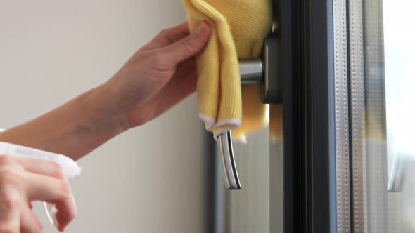 Hands Cleaning Window Handle with Detergent