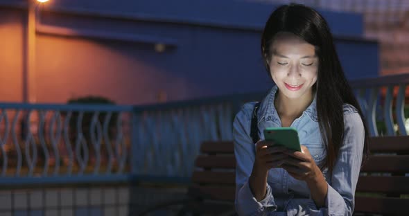 Woman looking at mobile phone in the evening