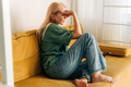 Depressed sad middle aged woman sitting on sofa at home. - PhotoDune Item for Sale