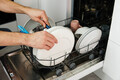 Washing dishes in the dishwasher. The man takes clean dishes from dishwasher. - PhotoDune Item for Sale