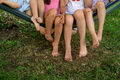 Close-up of bare feet of children sitting on hammock in park on lawn - PhotoDune Item for Sale