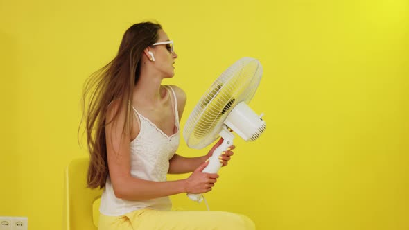 Sexy Woman With Long Hair Is Posing With Electric Fan