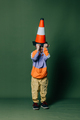 Stylish little boy with traffic cone on green background - PhotoDune Item for Sale