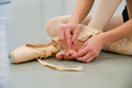 Ballerina putting on band aids on her barefoot sitting on the floor. - PhotoDune Item for Sale
