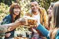 Happy friends cheering beer glasses in brewery pub garden  - PhotoDune Item for Sale