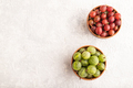 Fresh red and green gooseberry in clay bowl on gray concrete, top view, copy space. - PhotoDune Item for Sale