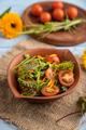 Vegetarian salad of tomatoes, marigold, microgreen on blue. Side view, selective focus. - PhotoDune Item for Sale