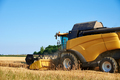 Combine harvester harvesting golden ripe wheat in agricultural field - PhotoDune Item for Sale