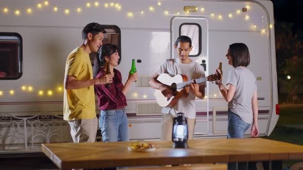 Group of Asian man and woman enjoy camping holiday party eating barbecue and drinking with happiness