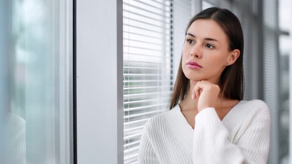 Pensive Business Woman Standing Near Window with Jalousie