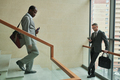 Mature African American businessman walking downstairs in business center - PhotoDune Item for Sale