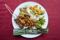 A plate of Indonesian vegtarian Nasi campur (Indonesian for mixed rice) with sate - PhotoDune Item for Sale