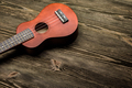 Hawaiian ukulele guitar on brown wooden background. - PhotoDune Item for Sale