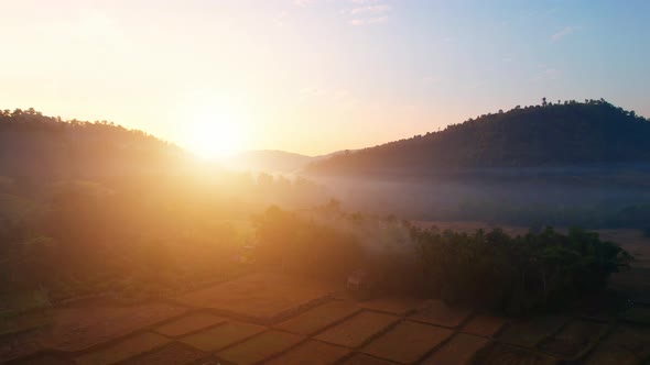 Aerial view from a drone over misty landscape on farmland. 4K