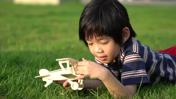 Cute Asian Child Playing Wooden Airplane In The Park Outdoors Slow Motion 