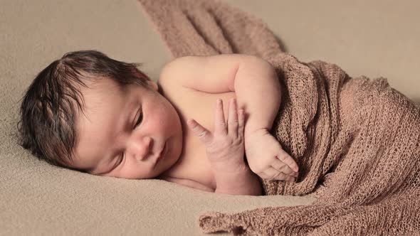 Cute infant girl lying in bed wake up close up. Looking at camera. Childhood. First days of new life