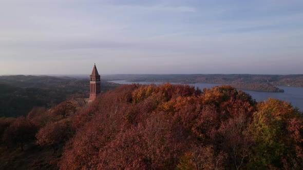 Drone Over Forest With Tower At Sunset