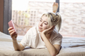 Relaxed woman using a smart phone in the morning on the bed at home - PhotoDune Item for Sale