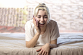 Relaxed woman using a smart phone in the morning on the bed at home - PhotoDune Item for Sale