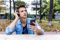 man listening to music from a smart phone on city background - PhotoDune Item for Sale