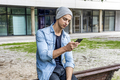 Attractive young smiling man using phone in a public park - PhotoDune Item for Sale