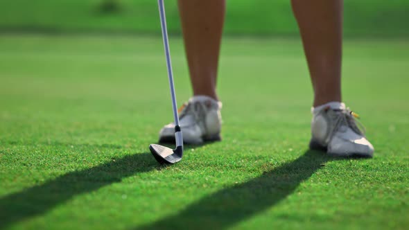 Lady Swinging Golf Club on Grass Course