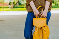 Female holding her yellow backpack, standing outdoor. - PhotoDune Item for Sale