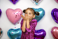 Girl in dress blows away confetti in shape of heart with palm on Valentine's Day - PhotoDune Item for Sale