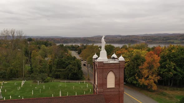 An aerial view of a statue of the Virgin Mary on top of a Catholic Church in upstate, NY. The drone