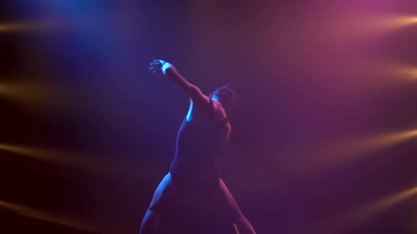 Professional Ballerina in Black Bodysuit Gracefully Dancing Ballet. Shot in Dynamic Spotlights and