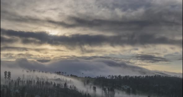 Timelapse of Evening Sun Rays Emerging Through the Cold Foggy Clouds in the Mountains