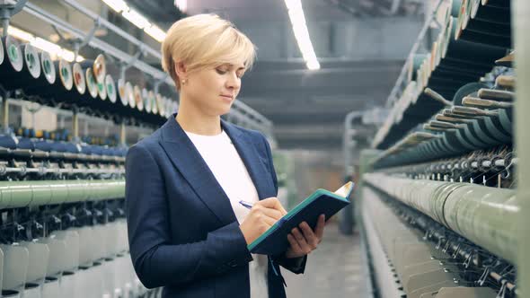 Female Expert is Taking Notes in the Textile Factory Unit