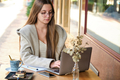 Business woman working remotely on a laptop in a coffee shop. - PhotoDune Item for Sale