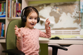 Young girl wearing headphones, enjoys her remote education. Distant studying, homeschooling. - PhotoDune Item for Sale