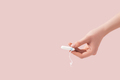 Tampon in a female hand against a pink background - PhotoDune Item for Sale