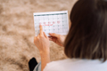 Lady looks at the days in the calendar menstrual cycle - PhotoDune Item for Sale