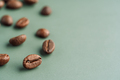 Coffee bean in focus close up against blurred beans on green background - PhotoDune Item for Sale