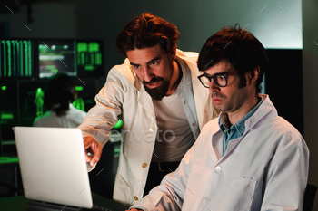 Two scientific male doctors with lab coat doing a medicine, biology or pharmacy investigation and