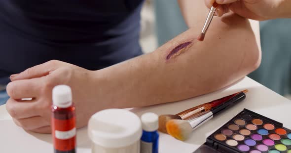 Close Up of Professional Making Fake Wound Makeup Special Effect on Arm