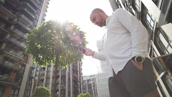 A Businessman is Texting on the Phone Near the Business Center