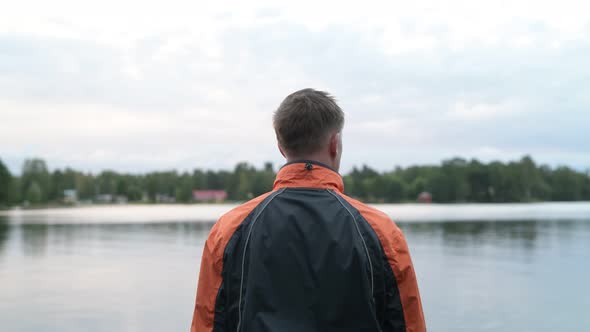 Rear View Of Young Man Enjoying The View Of The Lake