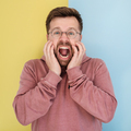 Man is stressed and screaming loudly, standing on a yellow-blue background. - PhotoDune Item for Sale