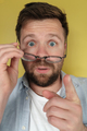 European man is surprised and at a bewildered, he holds his glasses and points with finger. Close-up - PhotoDune Item for Sale