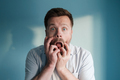 European man with a frightened, anxious expression stands against a blue background. - PhotoDune Item for Sale