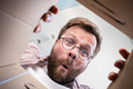 Man has unpacked a delivered package, looks at the contents with a surprised and funny expression - PhotoDune Item for Sale
